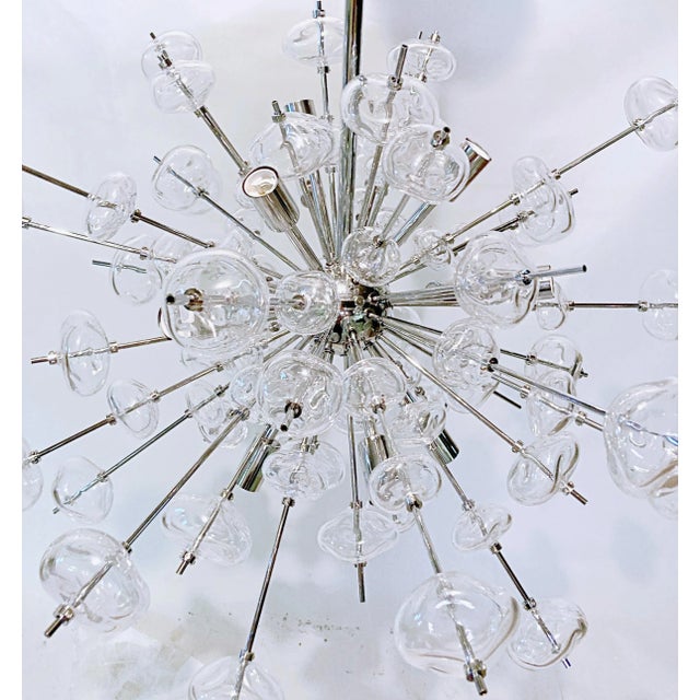 Modern chrome sputnik chandelier with hand blown orbs. It has 12 lights It can have an overall height of 32 and 40 inches....