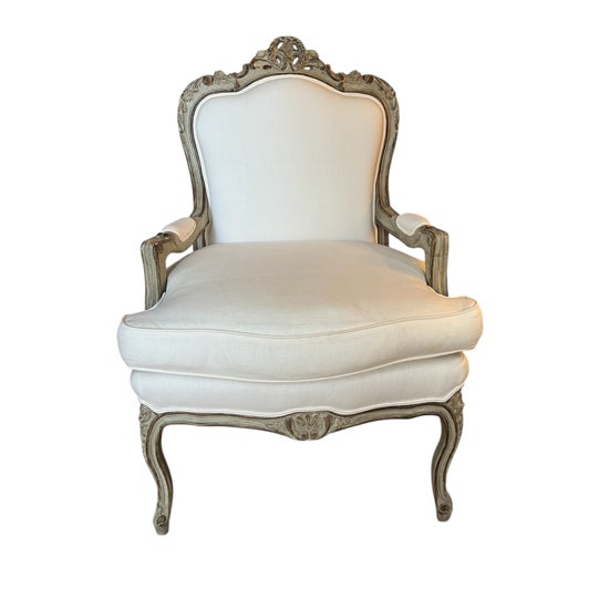 A pair of Louis XV-style upholstered Bergere armchairs with Rococo influence. These chairs with cabriole legs and a gently...