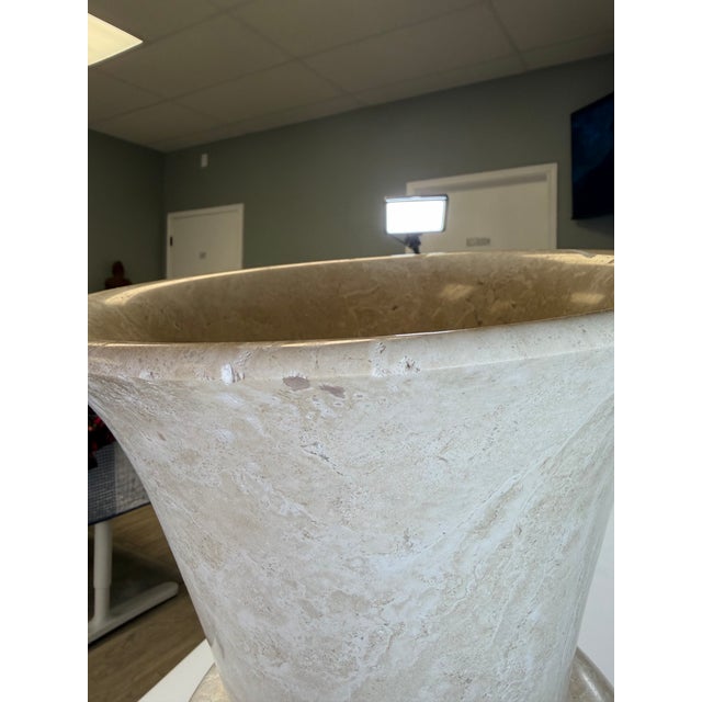 An impressive and monumentally scaled vintage hand-carved natural stone urn vase, featuring a timeless Neoclassical...