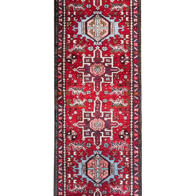 This mid-20th century Persian Heriz runner features a dynamic series of stylized floral medallions running its length,...