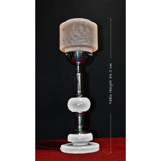 A striking original french art deco table lamp dating to circa 1940, combining polished white porcelain, chrome-plated...