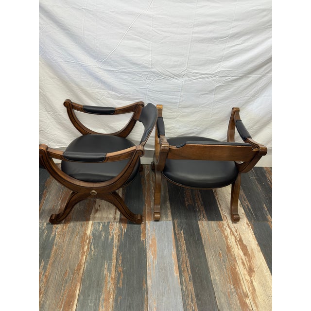 A spectacular, investment-grade pair of 1960s mid-century modern curule armchairs manufactured by elite heritage atelier...