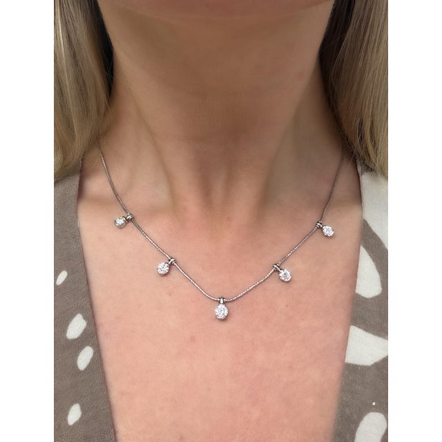 This classic necklace by Jose Hess contains five platinum half bezeled round brilliant cut diamond stations weighing...