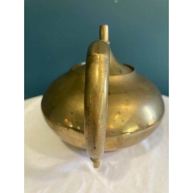 A handsome Mid-Century brass teapot featuring a faux bamboo handle and removable lid. Crafted in India, this substantial...