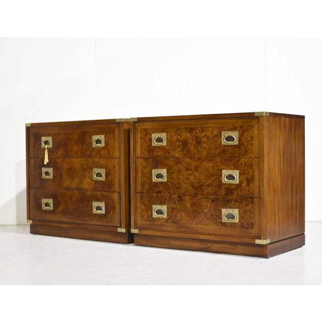 A striking pair of 1970s campaign chests by Hickory Furniture, these solid wood nightstands showcase beautiful burl wood...