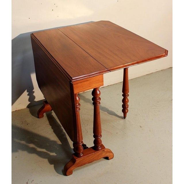 Small solid mahogany service table, very functional. It has a folding shutter on each side of the central part, offering a...