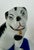A charming antique pair of porcelain pug dog figurines, each seated on a cobalt blue base. The dogs are modeled with...