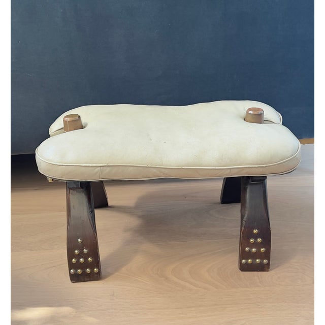 Mid century global decor classic: Camel saddle stool from northern Africa. This stool features a reversible cushion in...