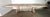 Italian carved wood painted trestle dining table with leaves. The table has a vintage, weathered look. It is made of wood...