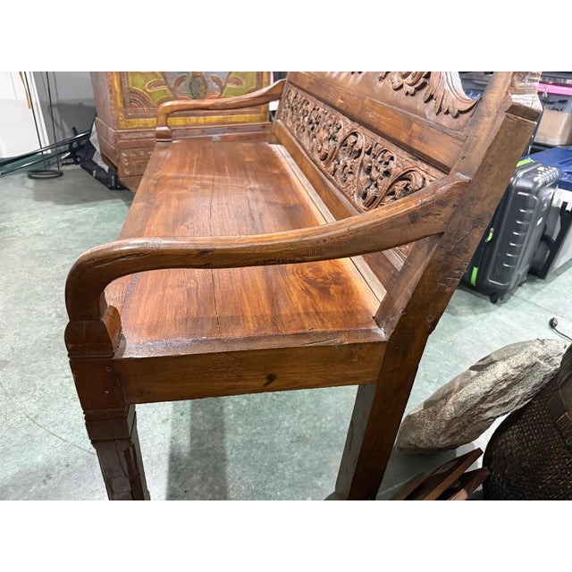 Beautiful antique wooden bench featuring an ornately hand-carved backrest with flowing scroll and floral details. This...