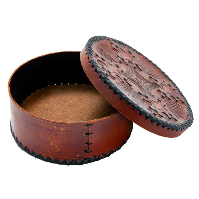 Hand tooled round leather basket, assembled also by hand by sewing the pieces tohether with glossy black fiber.