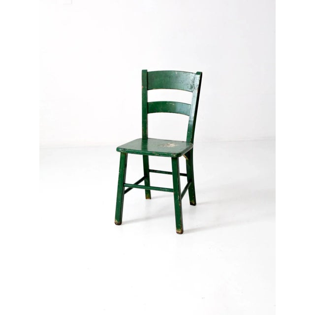 This is a vintage painted wood chair circa early 20th century. Original, vibrant green paint colors the wooden chair. It...