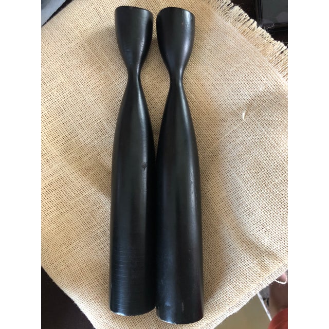 A pair of painted wood candlesticks that exemplify the classic mid century modern Danish design that has become a decor...