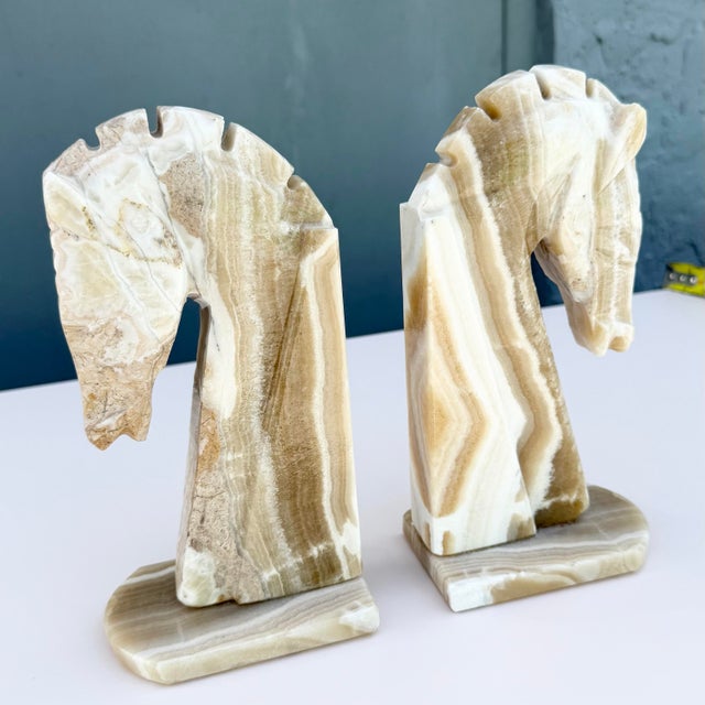 Striking pair of Mid-Century Modern horse head bookends hand carved from beautifully figured banded onyx marble. Each...