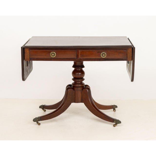Regency Mahogany Drop Leaf Sofa Table, on pedestal base with four brass mounted paw feet. Closed: 28.25" H x 37" W x...