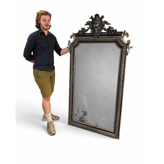 An exceptional Gothic Revival Victorian mirror, distinguished by its finely detailed black gesso frame enriched with...