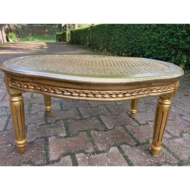 A refined 1950s French Louis XVI-style coffee table, beautifully crafted from solid beech wood with a woven cane top and a...