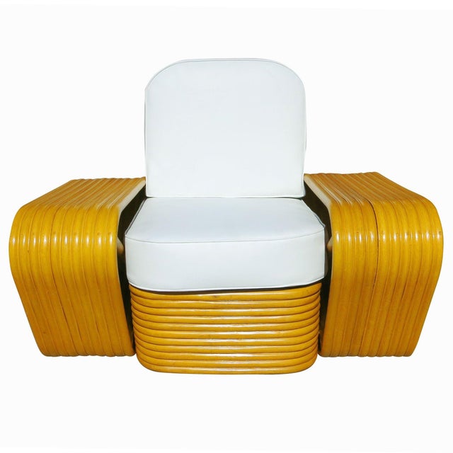 Beautifully restored Paul Frankl style rare ten-strand square pretzel rattan lounge chair with stacked rattan base. The...