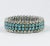 This is part of Chairish’s Costume Jewelry assortment. 1940's stretch metal bracelet of clear and turquoise rhinestones.