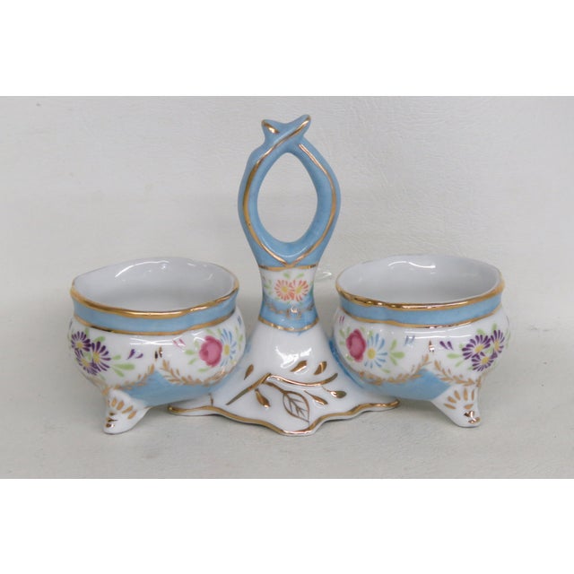 This lovely Limoges salt cellar presents a double open design and elegantly arched handle in the center, see pictures....