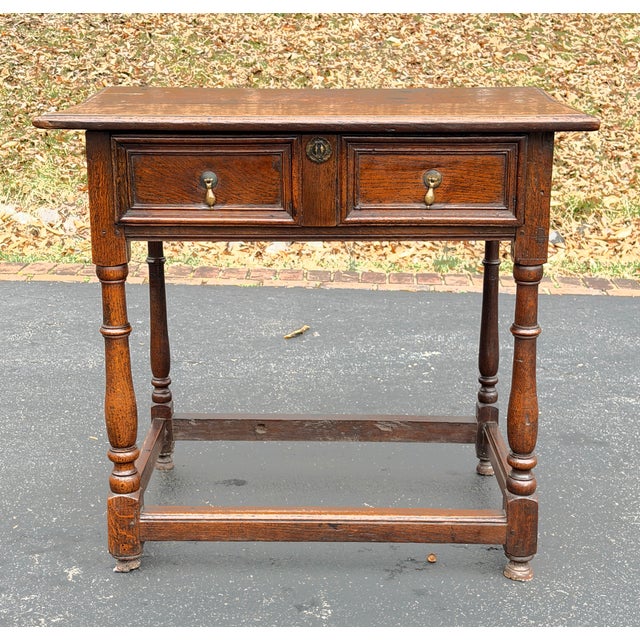 A charming and richly patinated English oak side table dating to the late 17th or early 18th century, with the restrained...