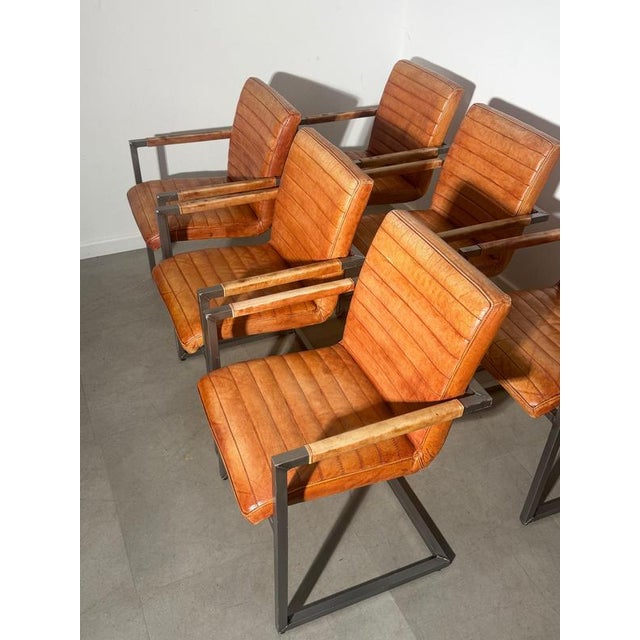 Striking set of six vintage dining or conference chairs, upholstered in warm cognac brown leather with distinctive...