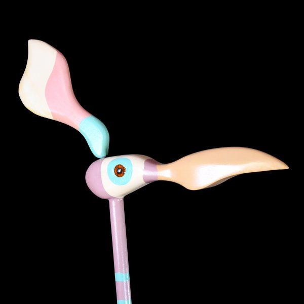 A whimsical hand-painted bird sculpture, the long-legged wading bird finished in pastel pink and turquoise on a round...