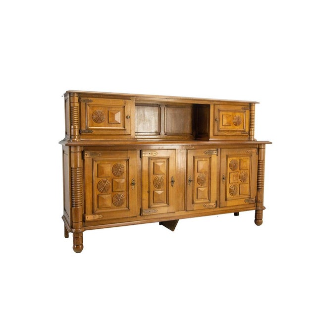 A two-section sideboard by charles dudouyt, made of oak with brass hardware. This exceptional sideboard is typical of...