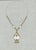 Original jewelry design for an elegant necklace with elongated white teardrop elements, gold-tone fittings and a large...
