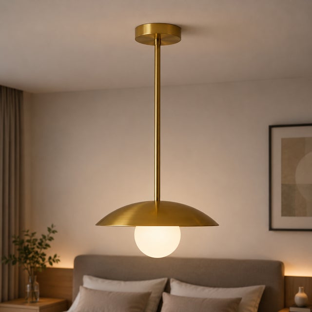 Crafted from solid brass, this pendant light features a clean disc-shaped shade paired with a softly illuminated opal...
