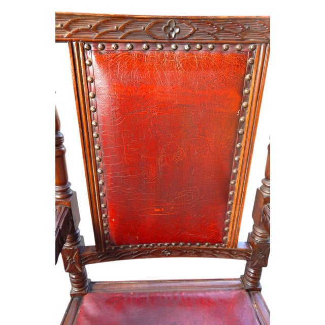 Heavily and ornately hand carved all over. Originally with a cane seat, replaced long ago with padded red leather. Sits...