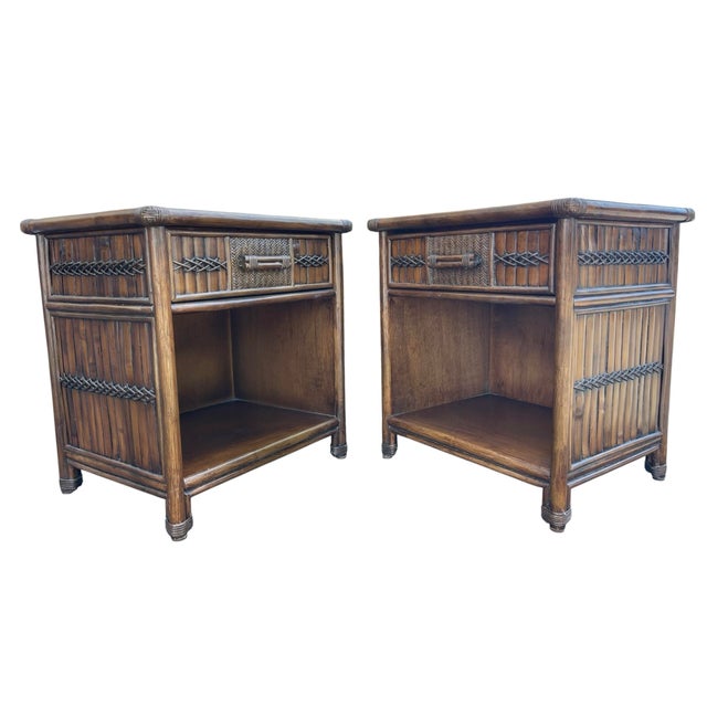A stylish pair of vintage coastal nightstands featuring rattan and carved wood construction with woven panel detailing....