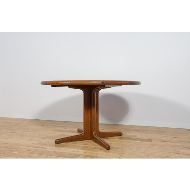 Round extendable table made of teak wood, produced in Denmark in the 1960s. The table has contoured, solid edges. The...
