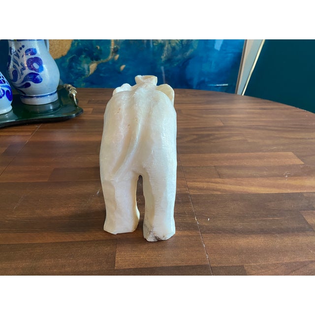 This elegant vintage alabaster elephant sculpture is a luminous statement piece, hand-carved from a single block of creamy...