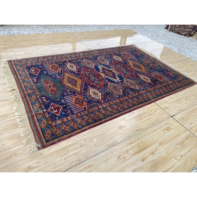 This vintage wool area rug is hand-knotted in the Baluch tribal design tradition. Measuring 6'8" x 10'4" (202 x 316 cm),...