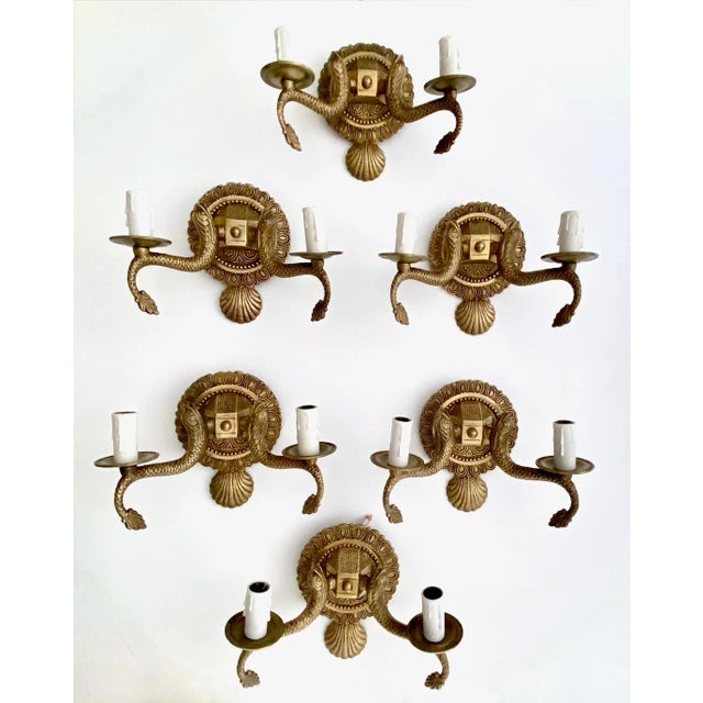 Set of six (6) of European two-light neoclassic style brass wall sconces with dolphin and claim shell motif. Expertly...