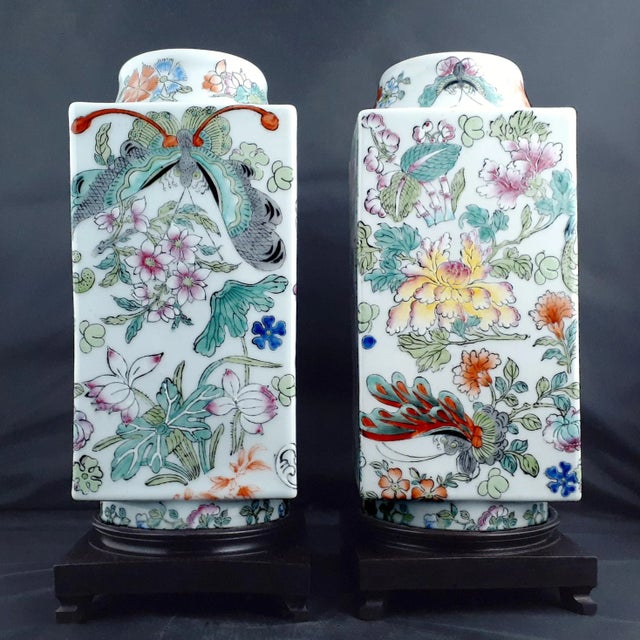 A matched pair of Chinese porcelain garden butterflies cong vases, with white glazed exteriors, interiors and inset bases....