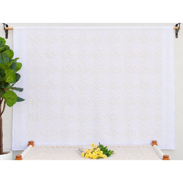 A lightweight cotton coverlet from Western India, beautifully adorned with intricate handcrafted appliqué cutwork. The...