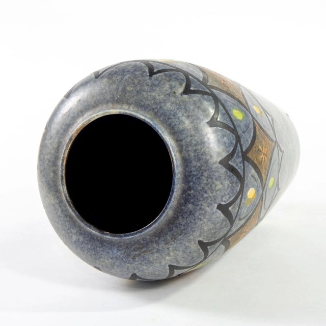 Circa 1960s West German tall ceramic vase has a gray blue glaze with a bold incised and glazed decorative border at the...