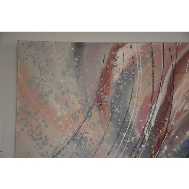 A piece of modern art with earthy tones of reds, blues and greys . This large abstract painting gives a subtle pop of...