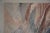A piece of modern art with earthy tones of reds, blues and greys . This large abstract painting gives a subtle pop of...