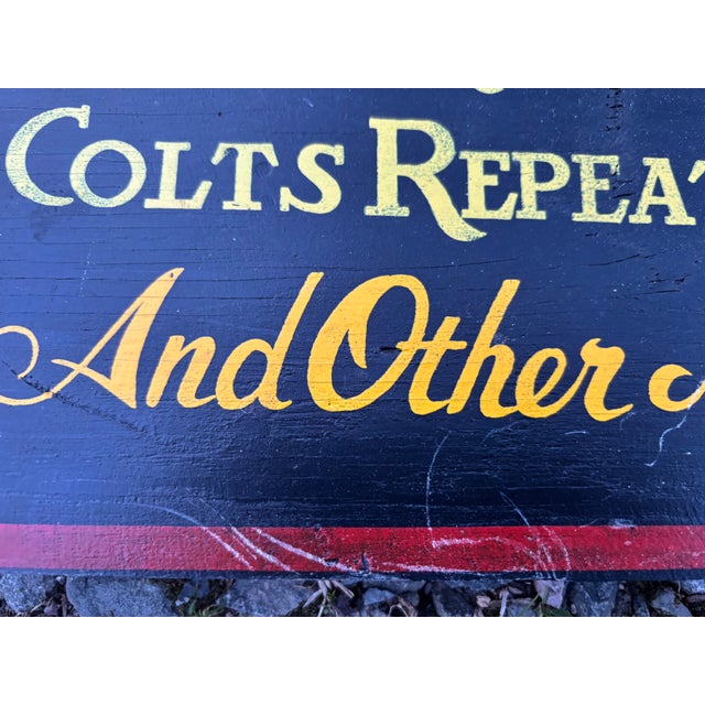 A colorful hand-painted trade sign for the Pawtucket Firearms Company featuring a 3D attached revolver, mounted on a...