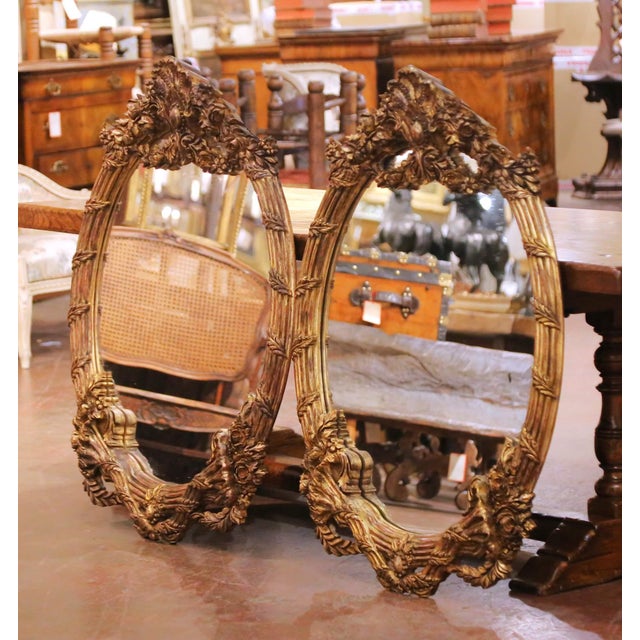 This elegant vintage pair of wall mirrors was carved in France circa 2000 and shaped in the Louis XV style. Oval in form,...