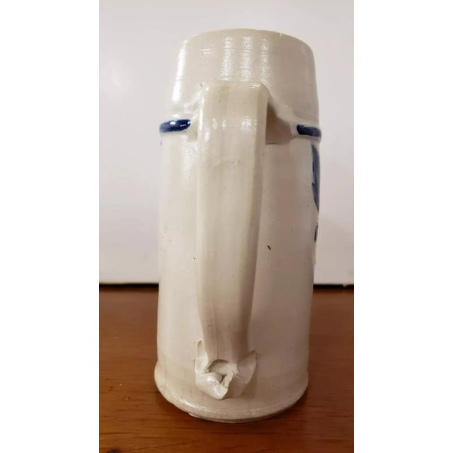 This is a Late 19th/Early 20th Century German Westerwald Salt Glaze Stein. It measures 7 1/8" high and 5 1/8“ wide to the...