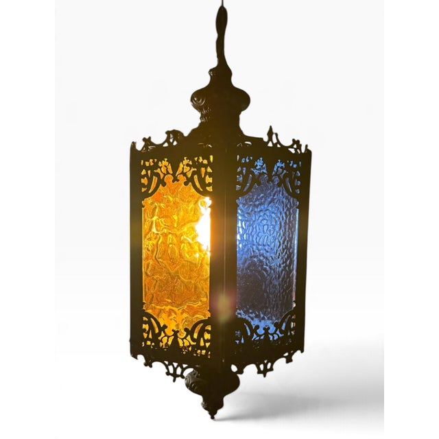 Rich blue and amber-orange textured glass brings jewel-toned color to this vintage Gothic-style swag lantern. Its six-...
