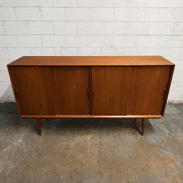 A vintage Danish teak Model 19 sideboard designed by Gunni Omann for Omann Jun, dating to the 1960s. The long cabinet is...