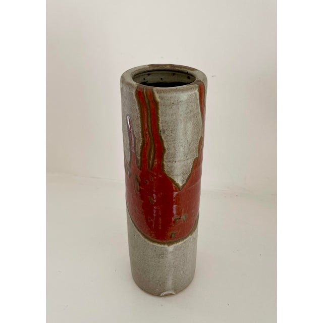 Beautiful pottery cylinder vase with abstract drip design. Shades of taupe, red orange & brown.