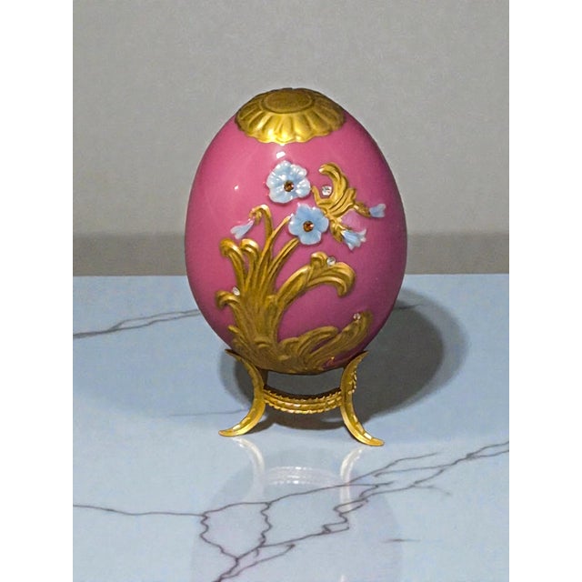 The Franklin Mint House of Faberge Imperial Porcelain Pink Floral Gilded Jeweled Egg is a stunning decorative collectible...