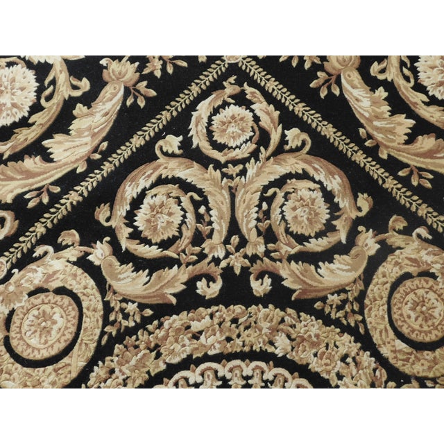High-quality hand knotted, Savonnerie carpet. Black and gold rug in wool pile on cotton foundation; featuring an ornate...