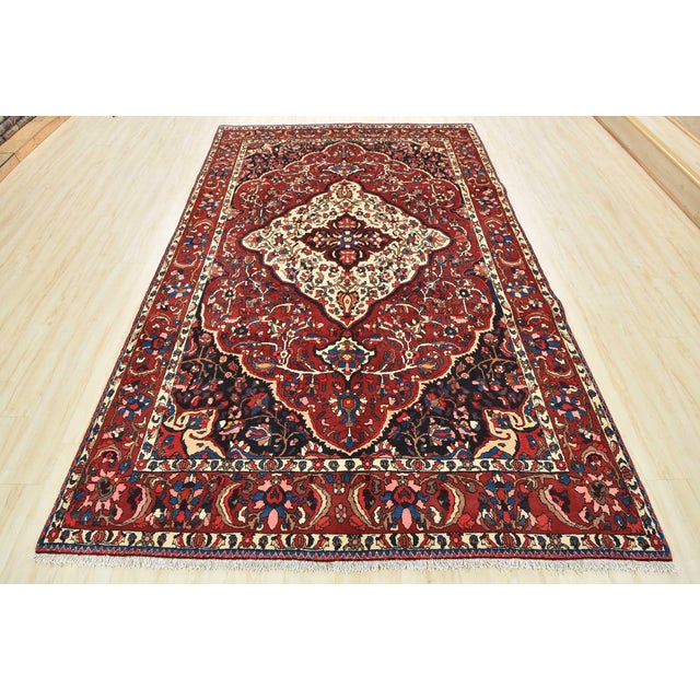 This authentic semi-antique traditional Bakhtiari rug is hand-knotted with an all-wool pile on a cotton foundation. This...